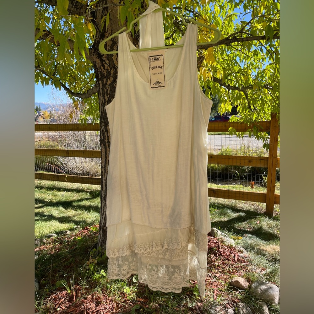 Vintage style cream dress with lace accents and scarf.